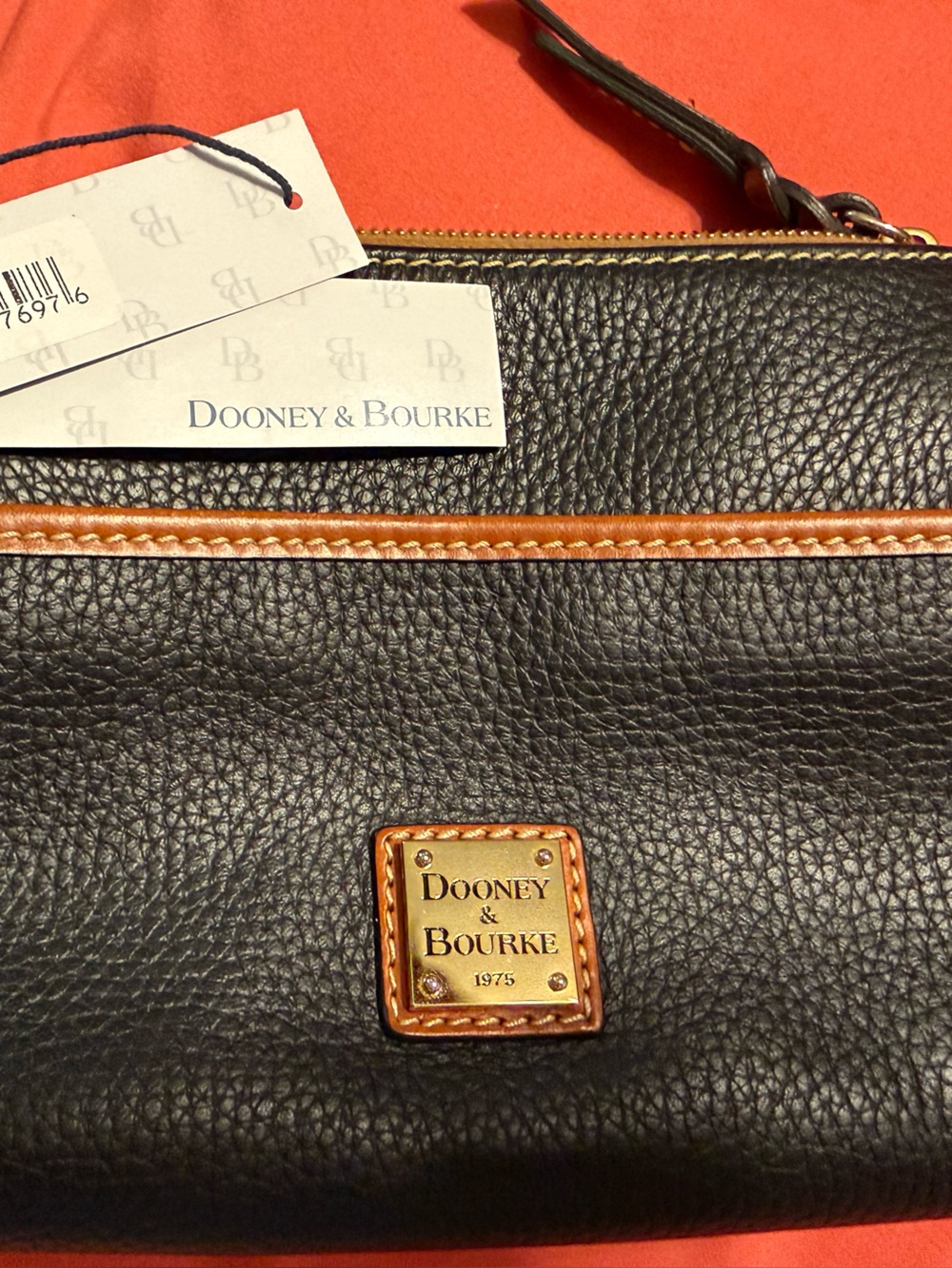 Dooney & Bourke Black Pebbled Leather Pouch with Brown Trim and Gold Plaque